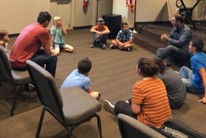 Group of young musicians sitting in a circle enjoying a lesson from the Bible about worship.